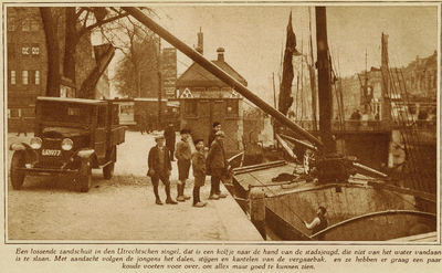 873842 Afbeelding van het lossen van een zandschuit aan de Catharijnekade te Utrecht, met op de achtergrond rechts de ...